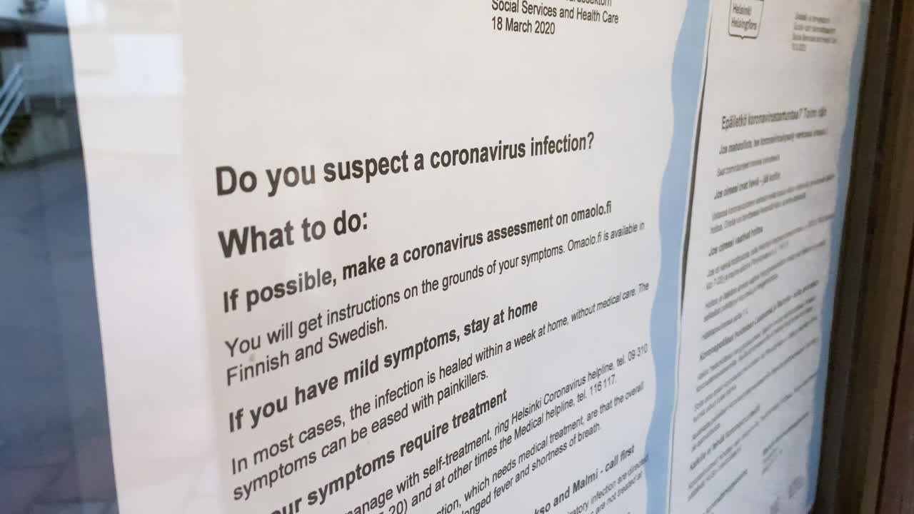 Coronavirus rules on a information glass, at a healthcare station - COVID-19, stay at home, flatten the curve - handheld view