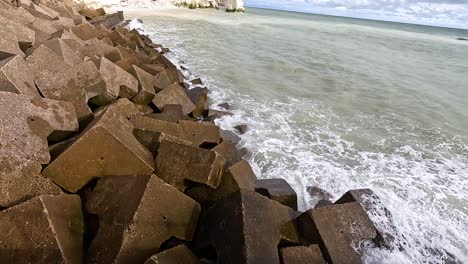 waves hitting concrete blocks on the shore