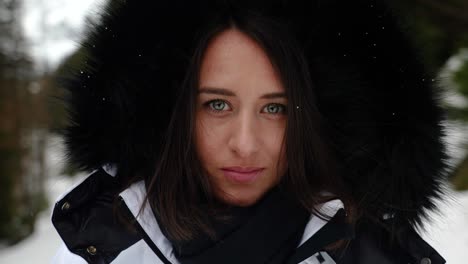 female in white winter jacket with black puffy hood turn and reveal face