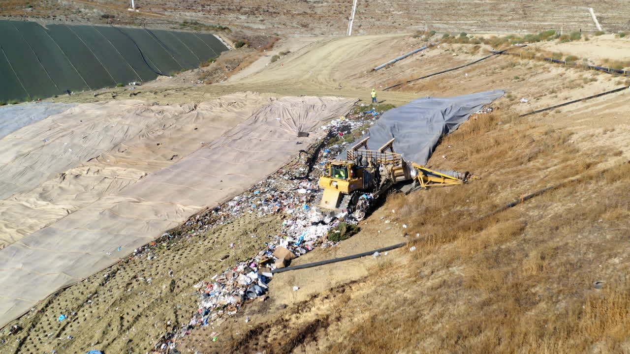 Aerial View of a Landfill with Heavy Machinery Compacting Waste