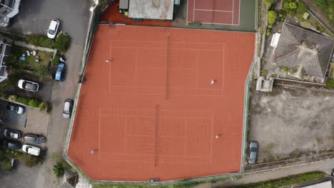 Canchas-De-Tenis-Rojas-Con-Parejas-De-Jugadores-Atléticos-Jugando-Durante-Un-Partido