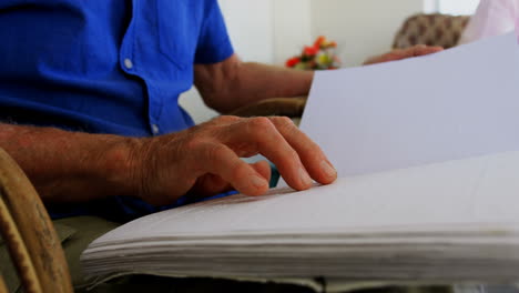 mid section of blind senior man reading a braille book at nursing home 4k