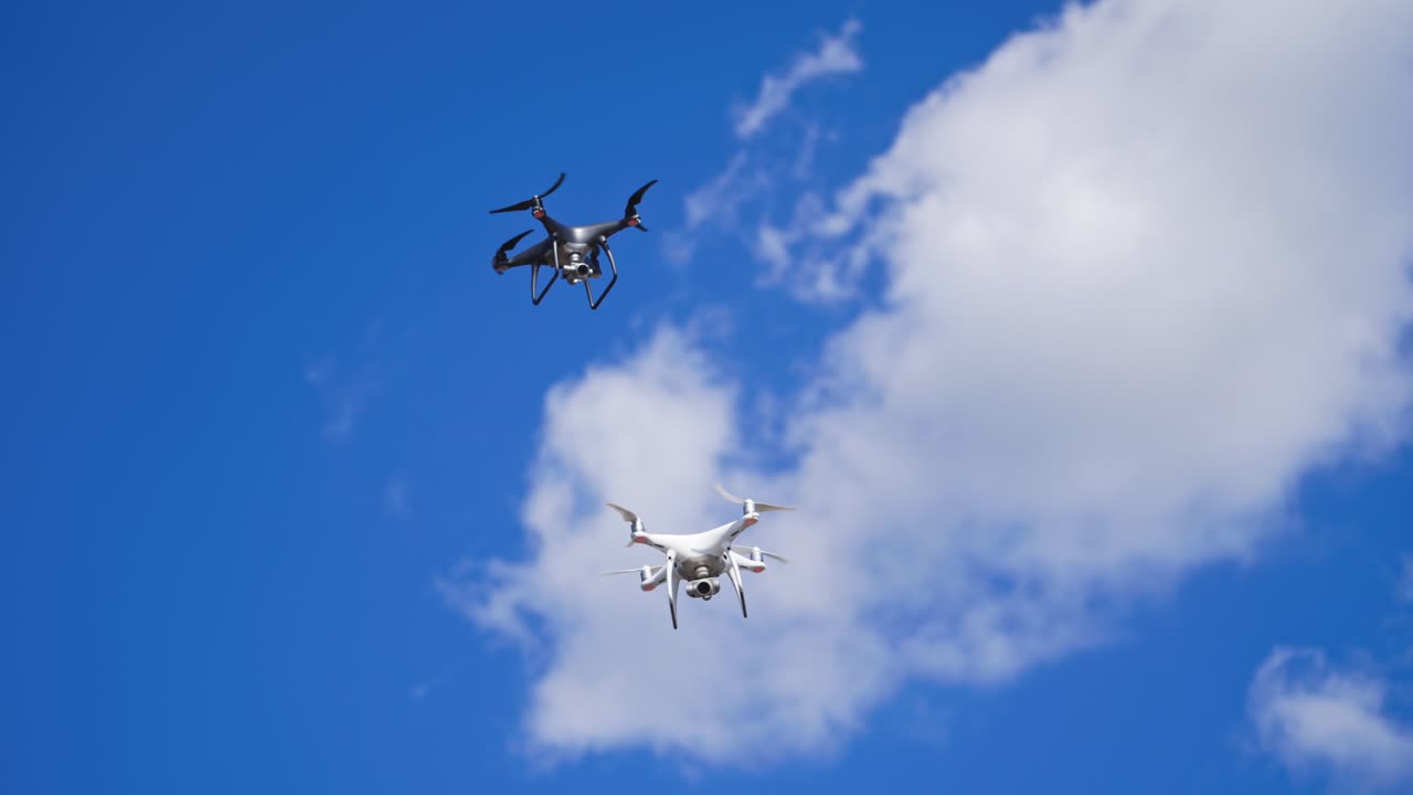Drones hovering across the sky. Two drone quad copters with high resolution digital camera flying