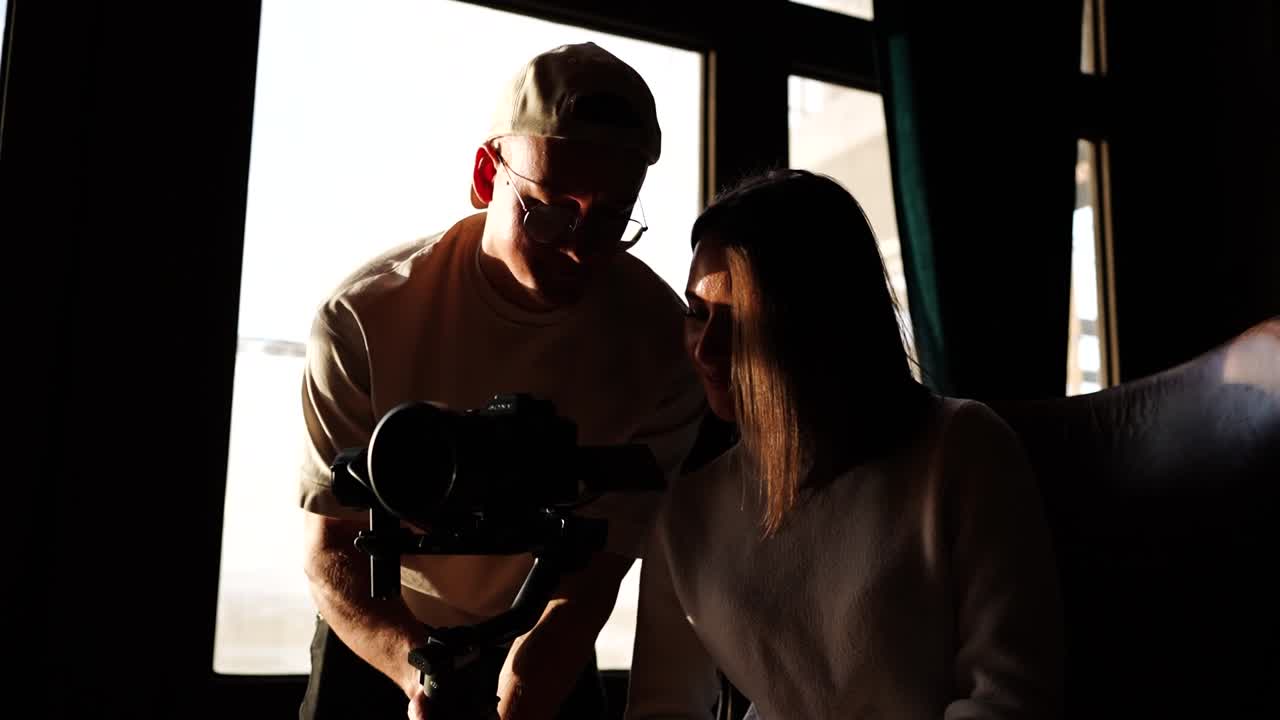 비디오 제작팀이 카메라에서 자료를 검토하고, 밝은 자연 조명 스튜디오