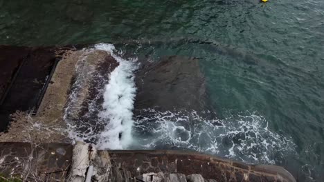 Cámara-Lenta-De-Olas-Rompiendo-Contra-El-Muelle-Pedregoso-En-El-Pueblo-De-Riomaggiore,-Italia,-Capturando-La-Potencia-Bruta-Y-La-Belleza-Serena-De-Esta-Escena-Costera