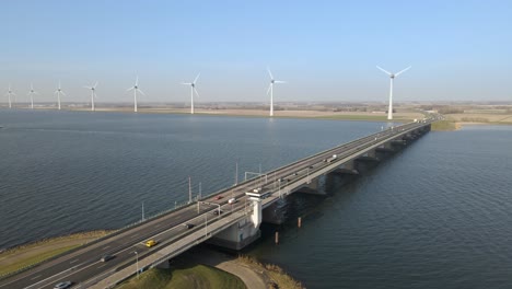 Drone-flying-along-bascule-brigde,-windmill-riverbank-landscape,-Ketelbrug-Bridge