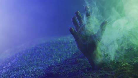 video of hand raising from grass with smoke on black background