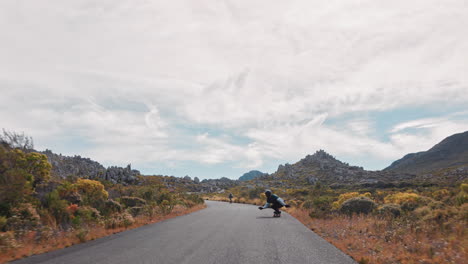 young-man-longboarding-riding-enjoying-competitive-race-cruising-on-countryside-road-friends-skating-together-using-skateboard-slow-motion