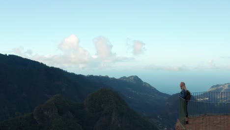 mujer camina hasta el final de la plataforma panorámica para disfrutar de un paisaje impresionante