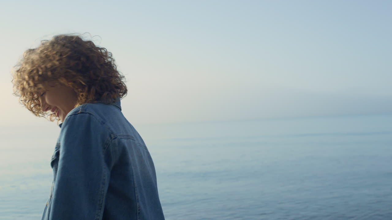 chica de moda posando en la orilla del mar. mujer sonriente dando la vuelta en la playa del océano