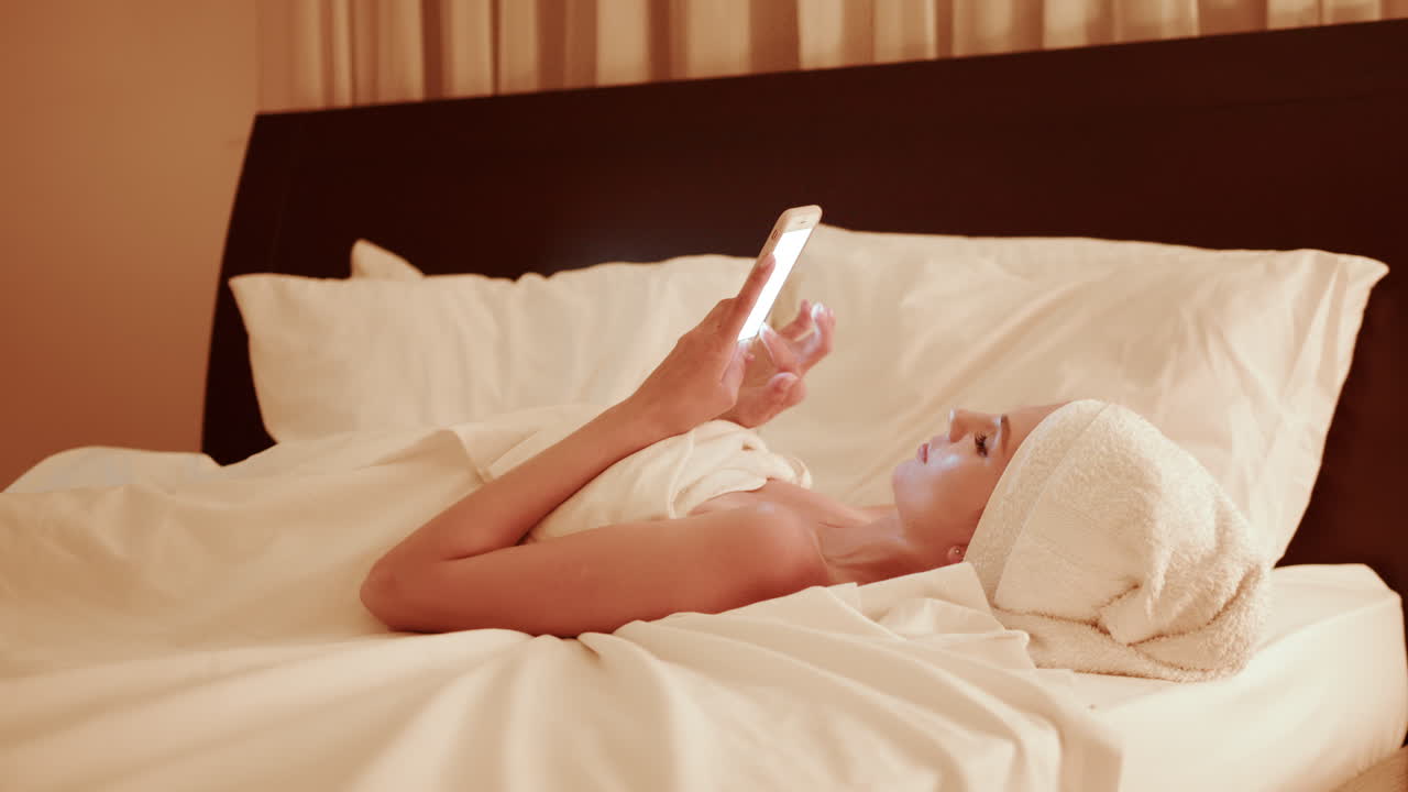 밤에 침대에서 드폰을 사용하는 여자