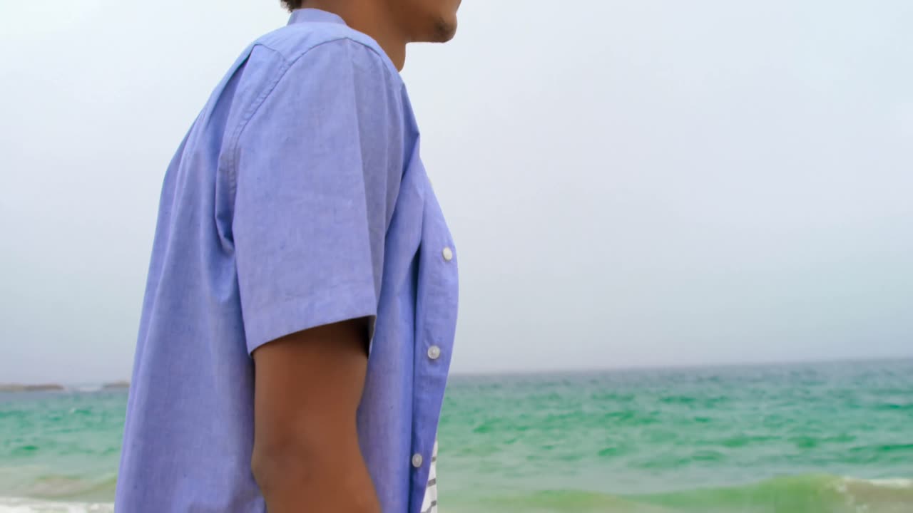 해변 4k에 서 있는 아프리카계 미국인 남자의 측면 뷰