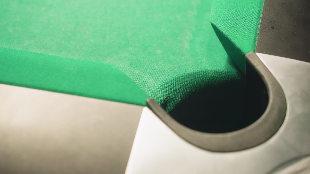 toma de primer plano de una pelota de billar roja rodando rápidamente en el bolsillo de la mesa de billar en la superficie verde. el borrón de movimiento captura la velocidad, la precisión y el momento final del tiro exitoso, destacando la precisión