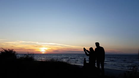 pareja joven viendo la puesta de sol en la playa