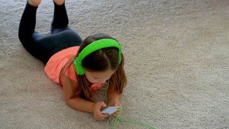 chica usando teléfono móvil en el suelo en casa 4k