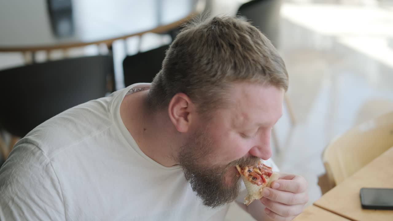 Hombre comiendo pizza.