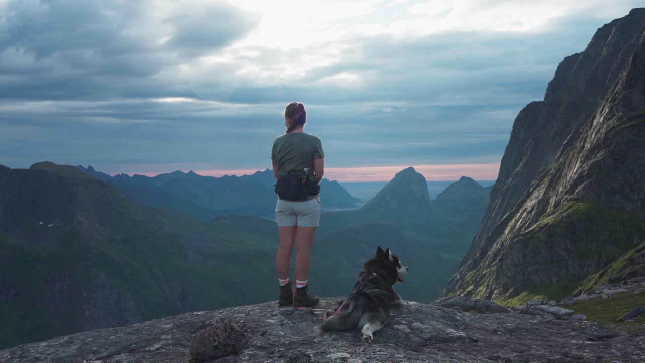 노르웨이 의 그리테티펜 봉우리 에서 알래스카 말라무트 애완 동물 과 함께 산책 하는 여자
