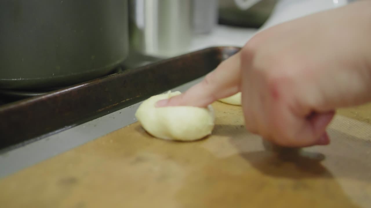 presionando una hendidura en las galletas de azúcar para hacer espacio para la mermelada