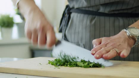 woman cutting parsley on wooden board