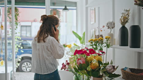 la mujer de negocios florista llama por teléfono al comprador del cliente. la chica ocupada habla digitalmente.