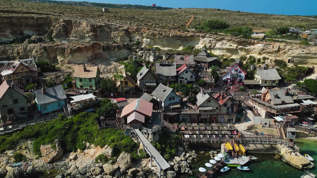 Aerial view of Popeye Village, Malta. Colorful seaside cottages, turquoise waters