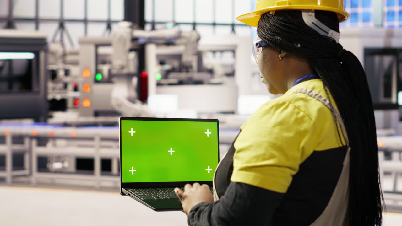 Vertical video Specialist using green screen laptop to conduct inspection in industry 4.0 plant