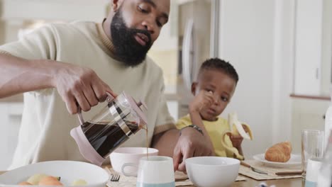 Padre-Afroamericano-Con-Hijo-E-Hija-Disfrutando-De-La-Comida-En-El-Comedor,-Cámara-Lenta