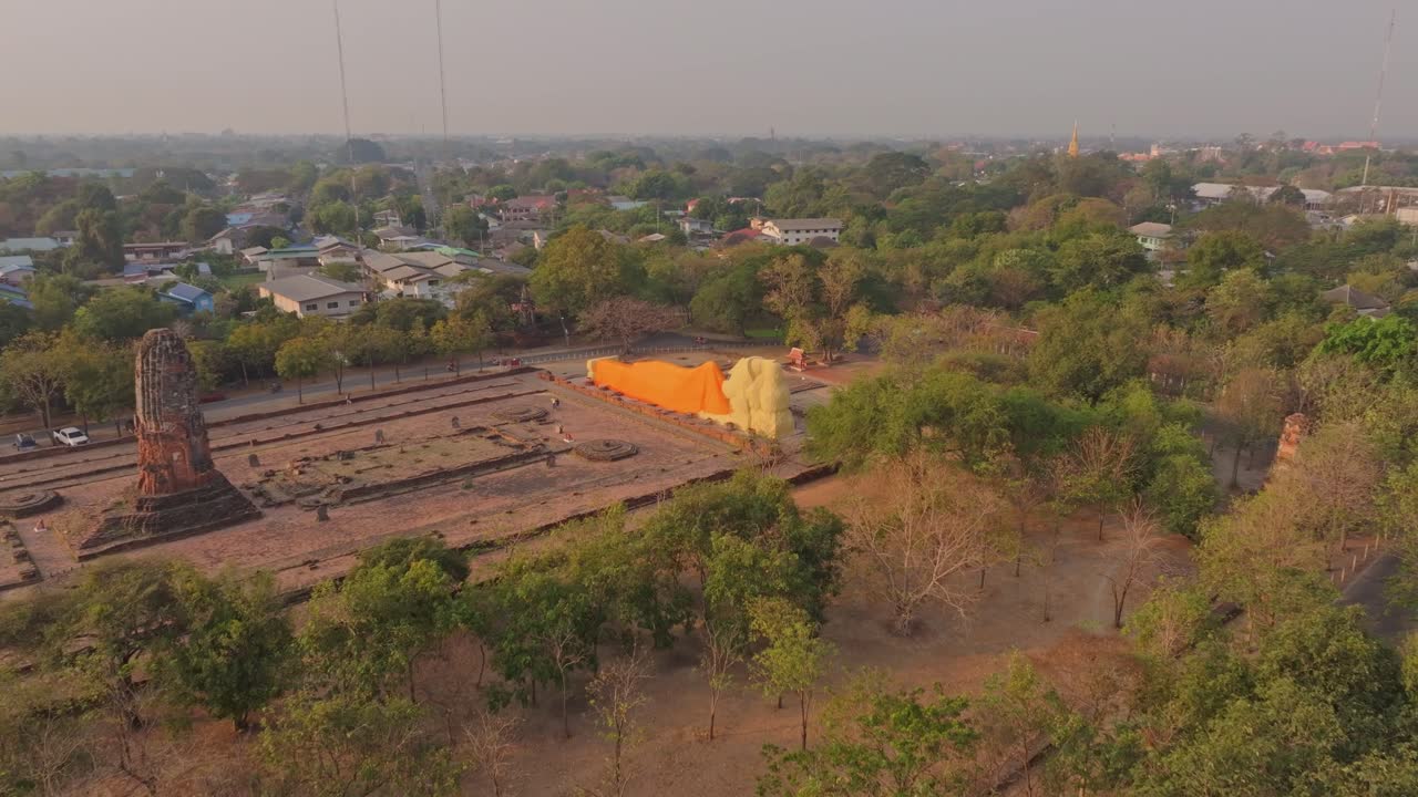 Ripresa con drone del gigantesco Buddha reclinato che si illumina all'alba, Ayutthaya