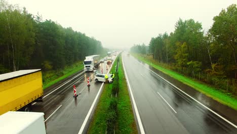 car crash traffic accident scene: a white car crashed into the barriers on the highway during a rainy day