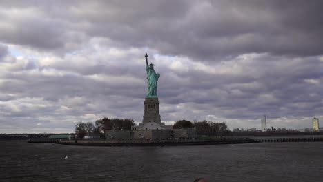 statue of liberty and new york skyline during a cloudy stormy day view from the ferry famous tourist destination