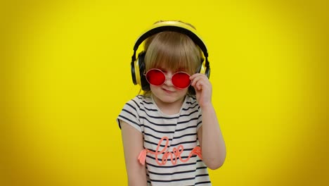 smiling cute kid child girl in headphones listening music blinking eye, smile, winking, flirting
