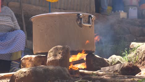 Großer-Kessel-Zum-Kochen-Des-Fleisches-Für-Die-Hochzeitsfeier-In-äthiopien,-Addis-Abeba,-Auf-Traditionelle-Weise,-Und-Streuen-Von-Kohle-Und-Dreck-Um-Den-Kessel,-Damit-Er-Nicht-Anbrennt