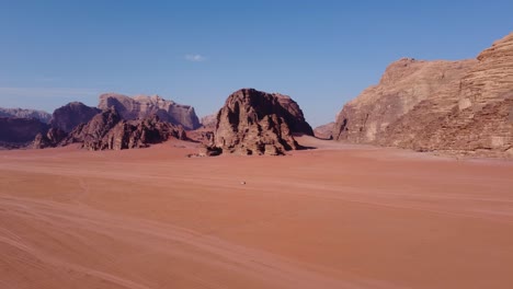 Aerial-view-of-a-car-drving-though-the-amazing-Wadi-Rum-desert-in-Jordan