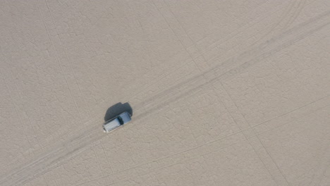 top view of 4x4 land vehicle driving across kubu island in makgadikgadi pans in bostwana on a sunny day