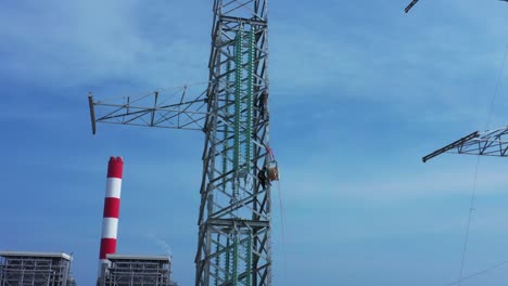 aerial drone footage of high-voltage power towers with prefabricated glass insulators to distribute electricity in an industrial park - development and industrialization concept