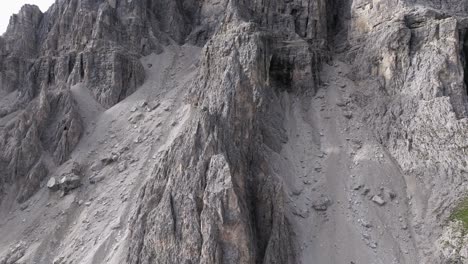 drone tilt-up over rugged dolomites cliffs, capturing layers and erosion details