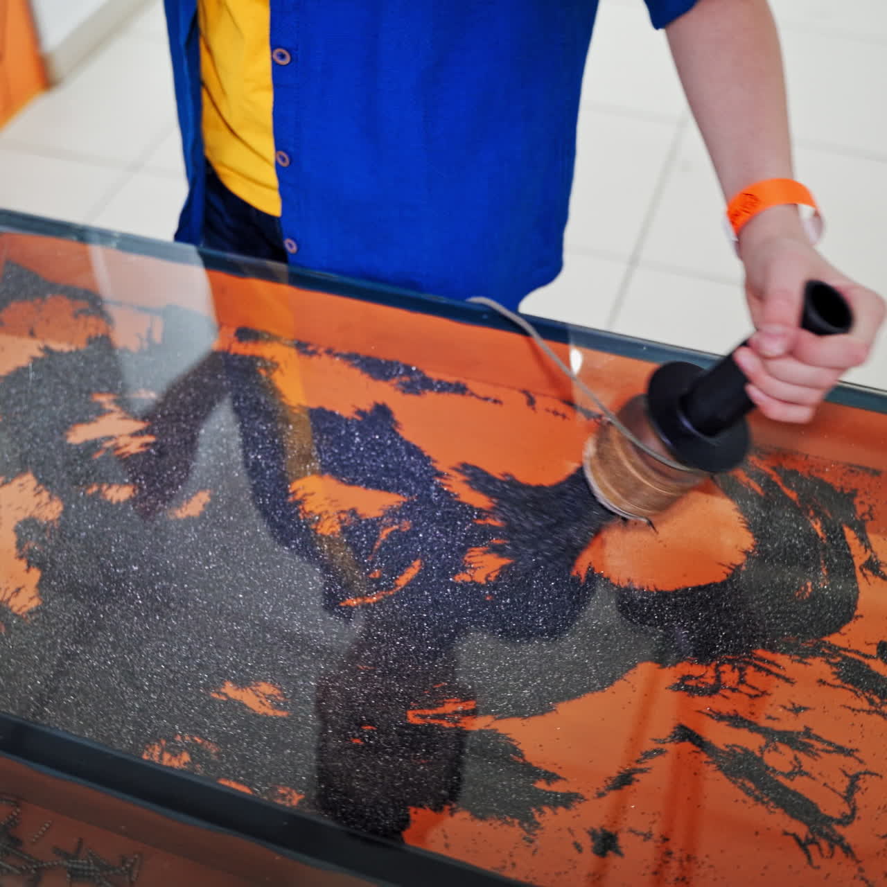 The boy play with iron powder in an entertainment and educational center. Science museum