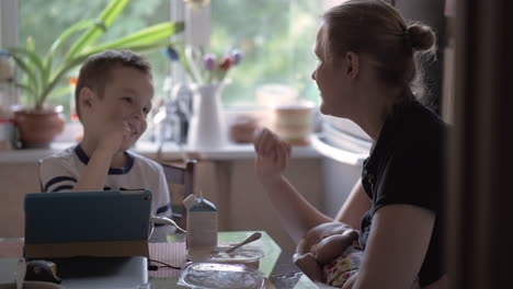 Mum-nursing-baby-and-playing-rock-paper-scissors-with-son