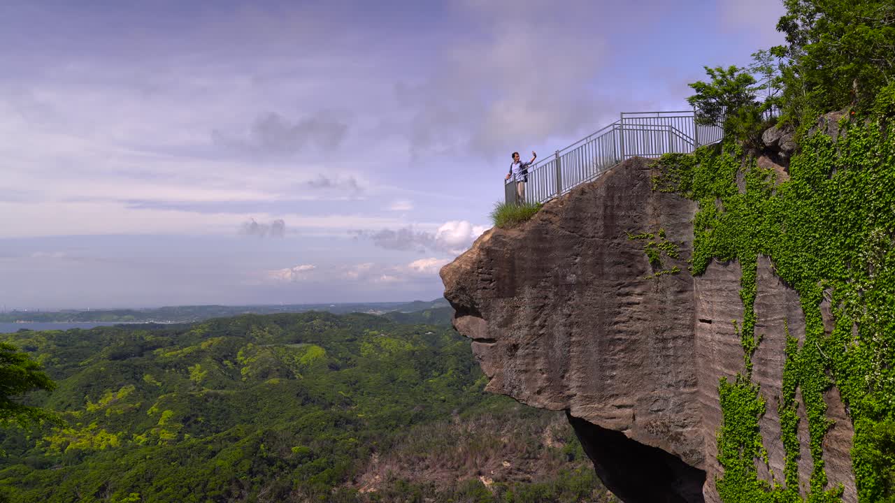 un turista masculino tomando selfies desde el punto de vista del monte nokogiriyama, japón - ancho