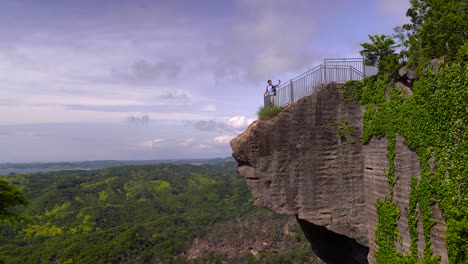 a male tourist taking selfies from the viewing point of mount nokogiriyama, japan - wide