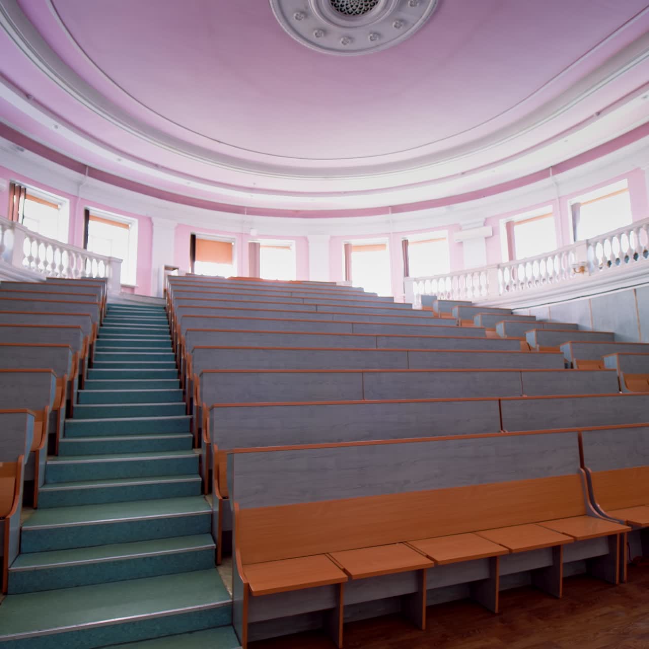 Beautiful conference hall with empty seats. Modern auditorium with wooden desks for lectures. Spacious university classroom without people