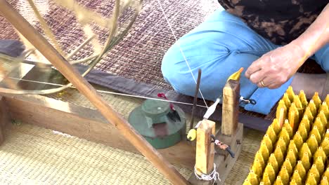 hands crafting silk threads in khao yai