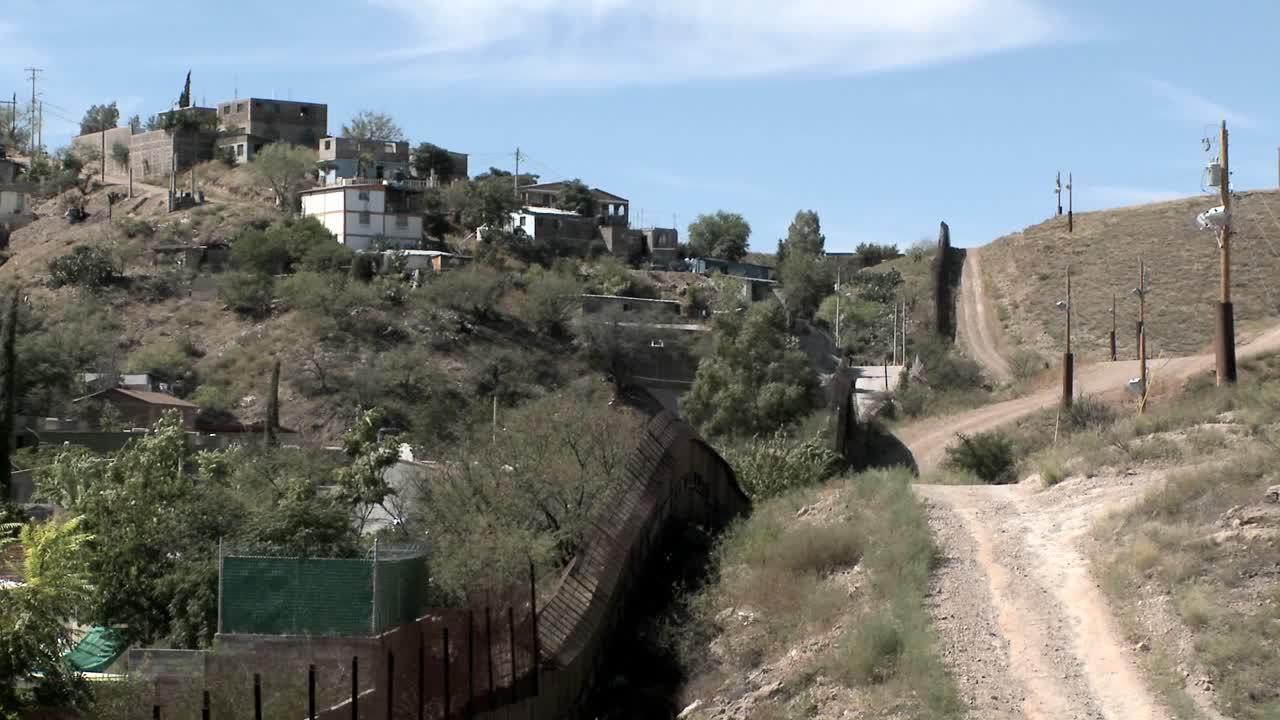 un grupo de edificios se asienta en la ladera de una colina los árboles soplan en el viento