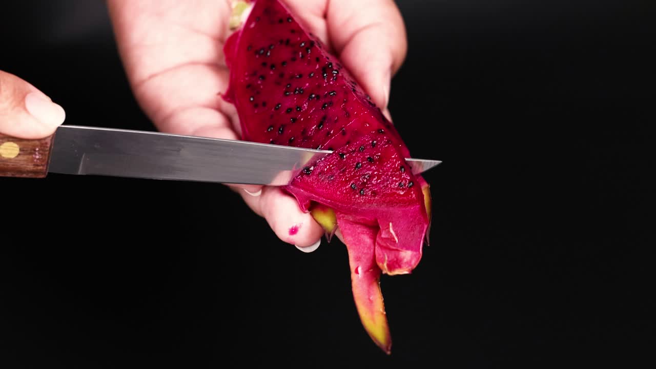 manos pelando frutas de dragón con un cuchillo