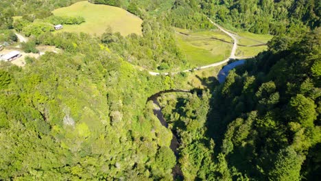 Drone-flyover-in-a-natural-environment-at-sunset,-Tocoihue-waterfall,-Dalcahue,-Chiloé-Archipelago