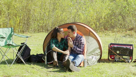 adorable young couple having a sweet moment in camping tent