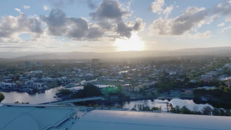 4k uhd panning view of casino construction, convention centre on the nerang river at sunset in downtown broadbeach district, gold coast australia, aerial view. commuter tram, gold coast beach life.