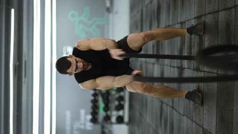 Attraktiver-Muskulöser-Mann,-Der-Im-Fitnessstudio-Mit-Kampfseilen-Mit-Hoher-Intensität-Trainiert