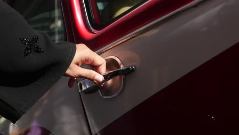 woman opening the door of a classic red car