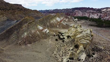 Vista-De-Un-Camino-En-Una-Llanura-De-Un-Cañón-Donde-Hay-Pequeñas-Montañas,-Vista-De-Pájaro,-Cámara-Lenta-Sobre-El-Camino-Del-Cañón-De-Cottonwood-Utah